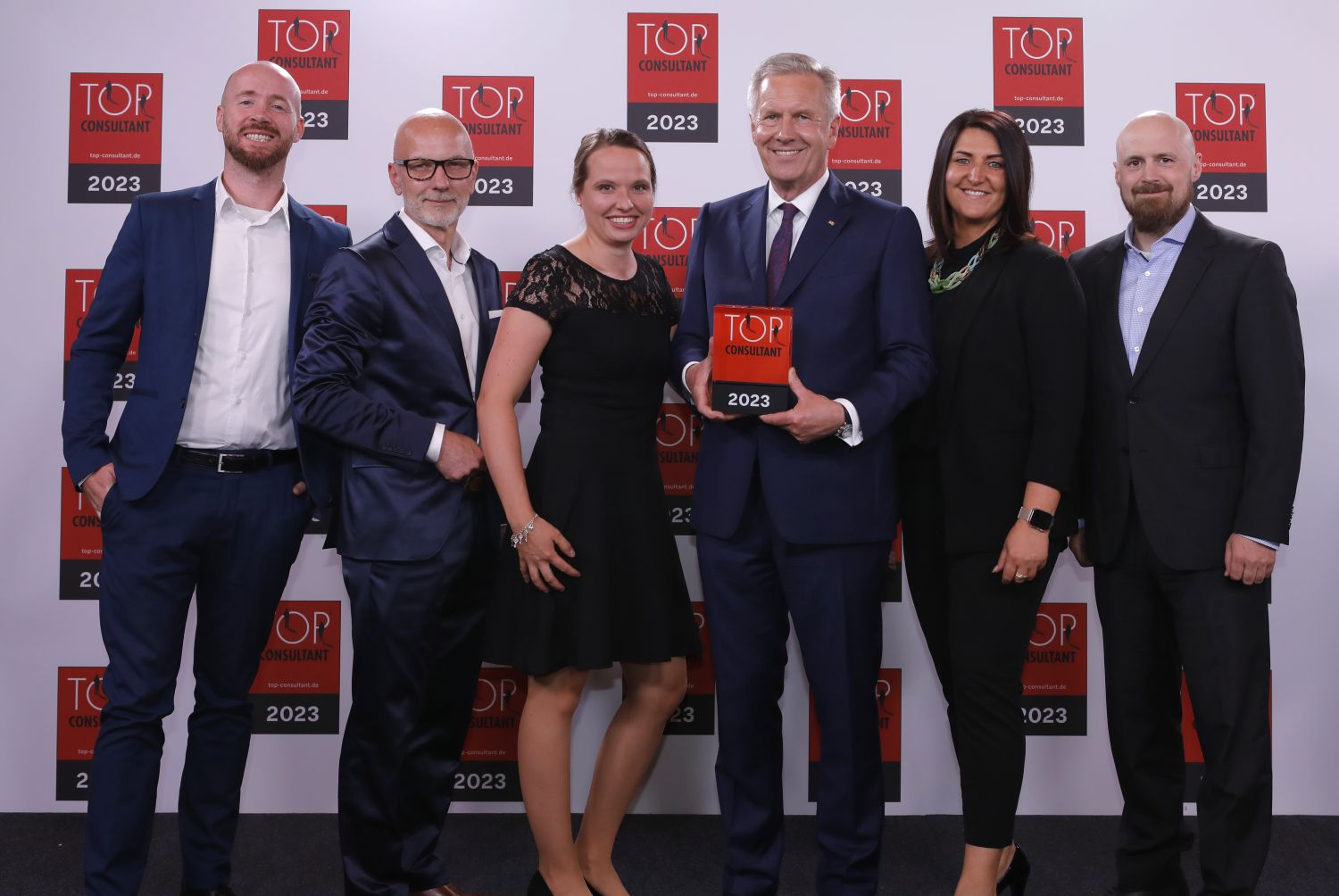 bluecue ist TOP CONSULTANT 2023 - Frederik Hanke, Christian Meetz, Johanna Möller, Dr. Inga Knoche und Torben Volkmann mit Bundespräsident a.D. Christian Wulff (Foto: KD Busch / compamedia)